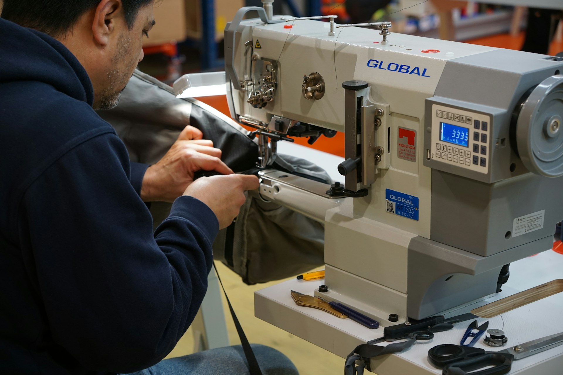 Operator stitching a bag panel on an industrial machine at the Chennai unit